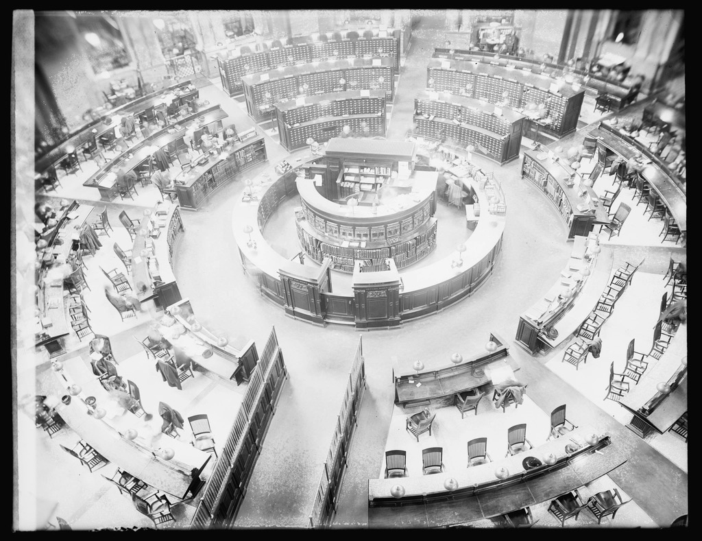 The Library of Congress main reading room, photographed from above: circular reading desks surrounded by card-catalog cabinets.